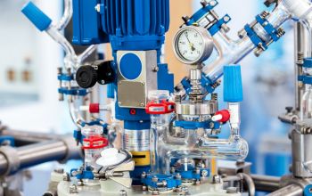 Close-up view of industrial solenoid valve system with pressure gauges in a chemical processing plant, illustrating advanced fluid control technology